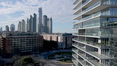 high-rise apartment buildings in a modern residential area with skyscrapers in the background. aerial reveal shot