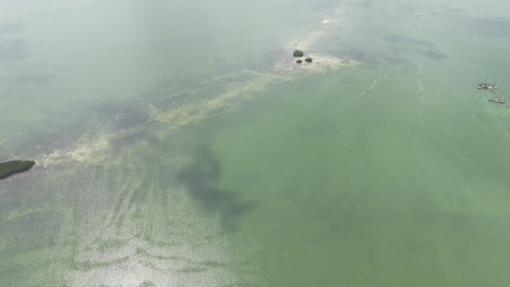 revealing drone shot of the lagoon and cancun city in the back on a hazy day