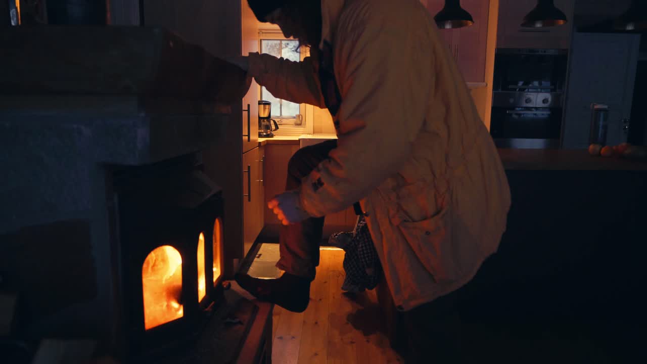 벽난로 옆에서 몸을 따뜻하게 하는 집안의 한 남자의 옆모습