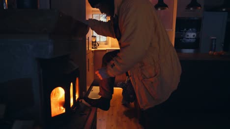 side portrait of a man in the house warming self by the fireplace