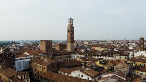 drone shot of a looming brick tower standing over verona, italy