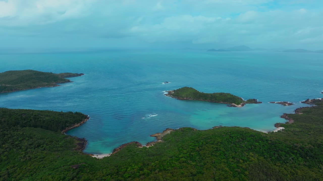 playa de whitehaven isla de whitsundays drone aéreo línea costera de arbusto sereno parque nacional de airlie australia aus qld sol nublado cielo azul exterior gran barrera de arrecifes azul claro agua océano círculo movimiento derecho