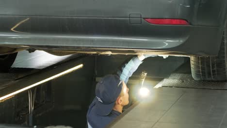 mechanic inspecting a car under a lift