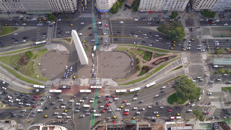 Top down aerial drone view of the Obelisk traffic circle with busy streets and vehicles in Buenos Aires Argentina