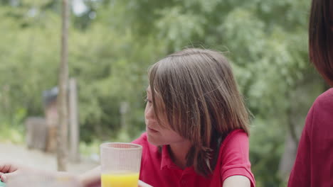 hermanos limpiándose la boca con una servilleta después de la cena