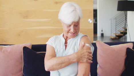 Video-of-happy-caucasian-senior-woman-showing-plaster-after-vaccination