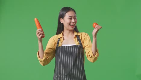 woman holding carrot and tomato