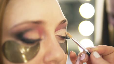 Make-up-Künstler,-Der-Leichte-Augenschatten-Auf-Das-Auge-Des-Modells-Legt.-Nahansicht.-Flecken.-Seitenansicht