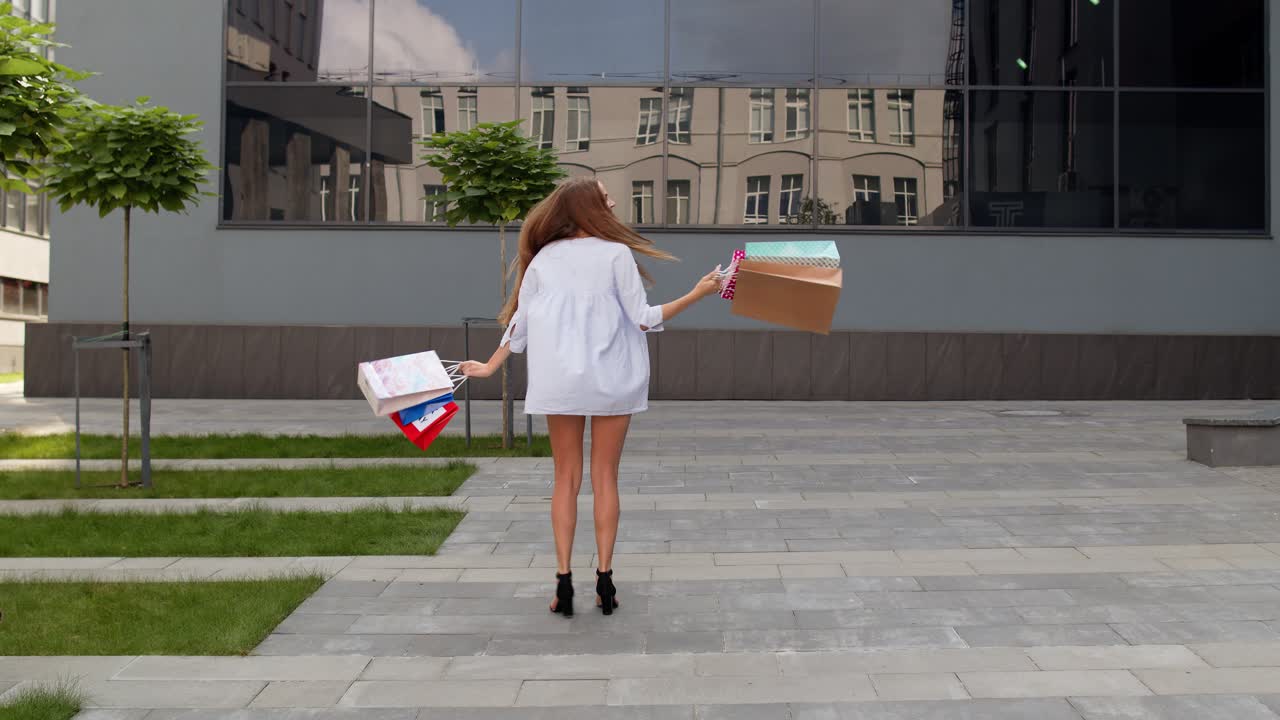 chica elegante con bolsas de compras, regocijándose con los descuentos en la tienda, bailando, celebrando. viernes negro
