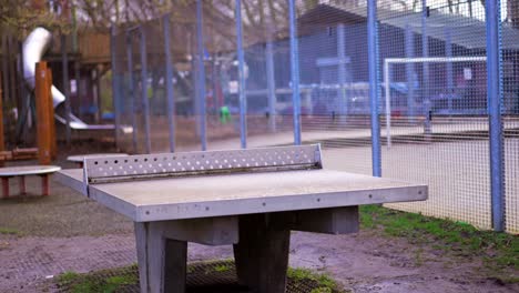 Playground during Covid-19 Coronavirus pandemic, empty scenery during lockdown, unused ping-pong table tennis table and football city court