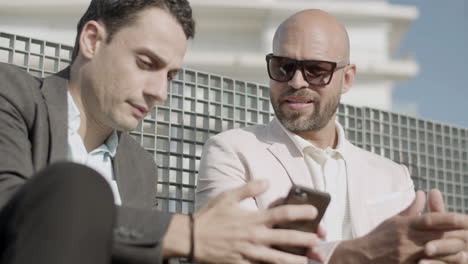 close-up of business partners looking at phone screen outdoor