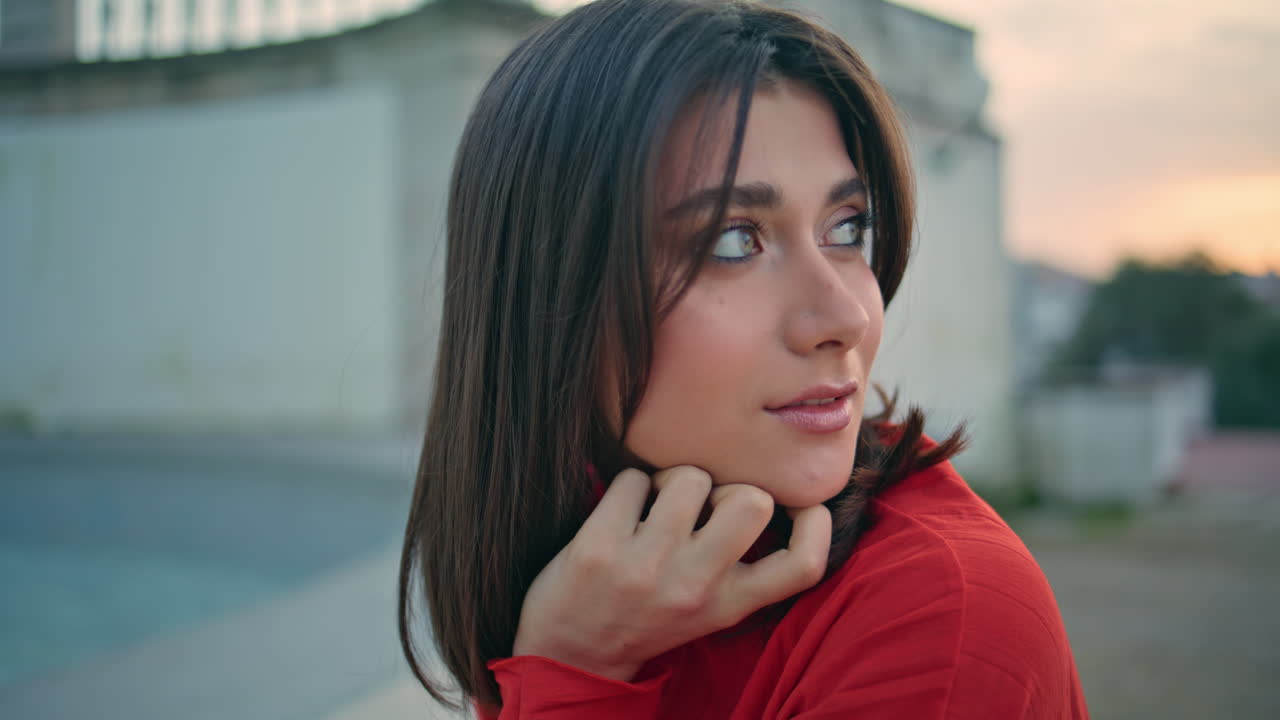 Brunette lady posing fountain in city portrait. Smiling woman resting evening