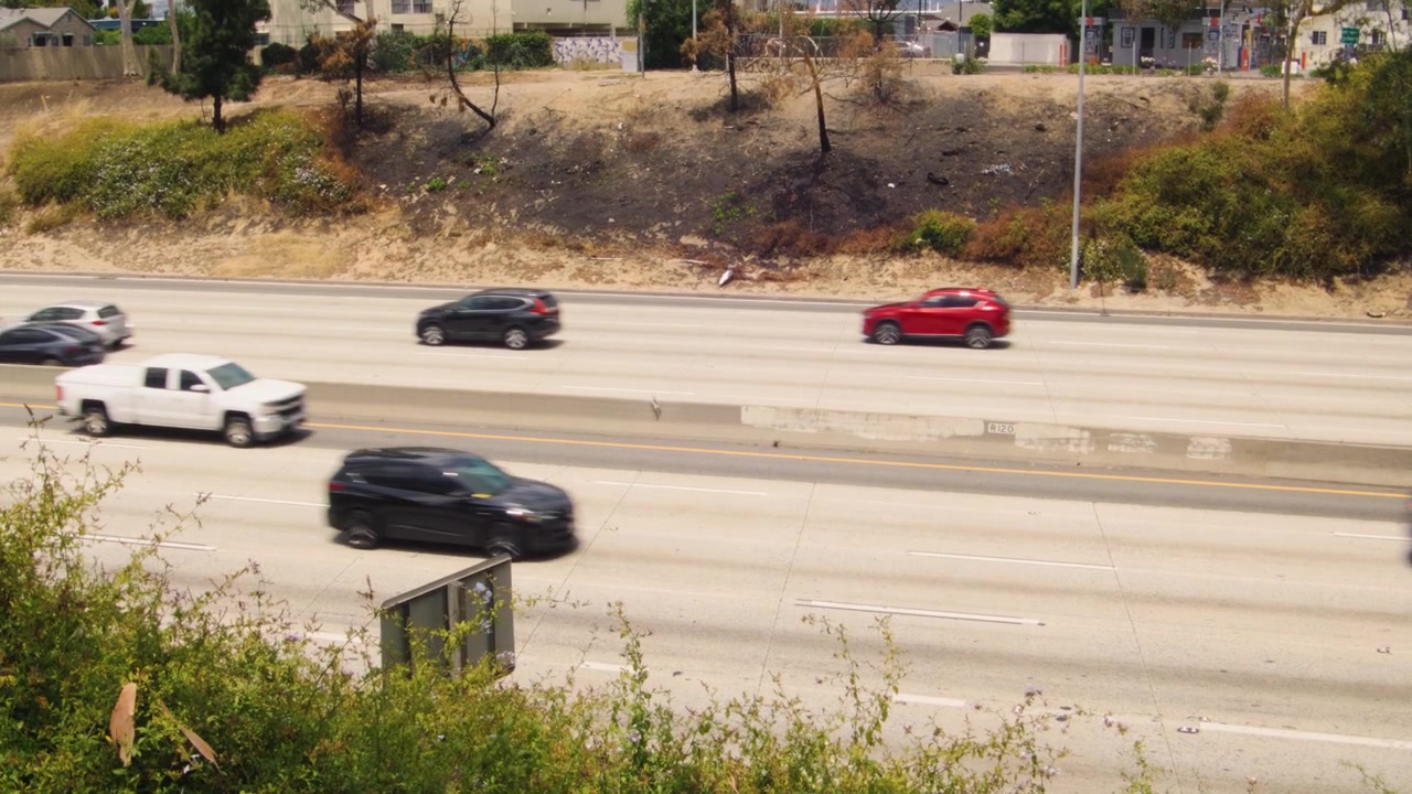 Forhøjet udsigt over trafik på motorvej i Los Angeles, vidvinkelbillede, solrig bymotorvej i dagtimerne