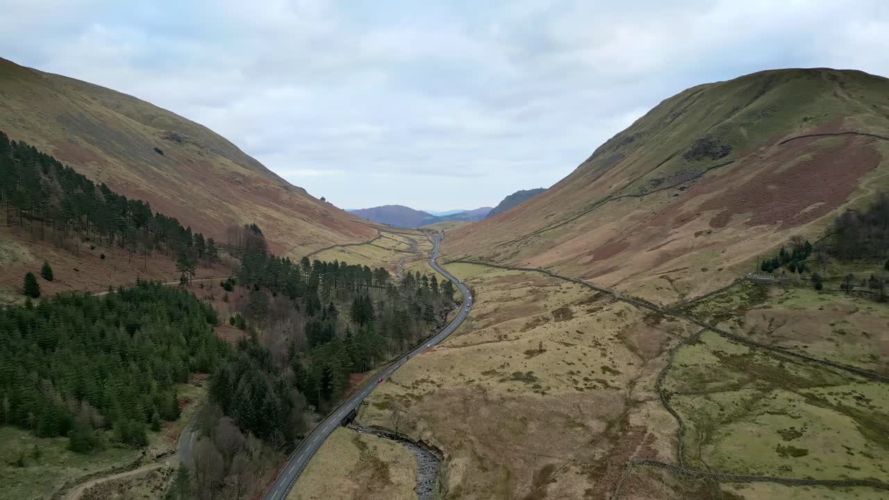 Aerial footage of Lakeland fells with narrow country road
