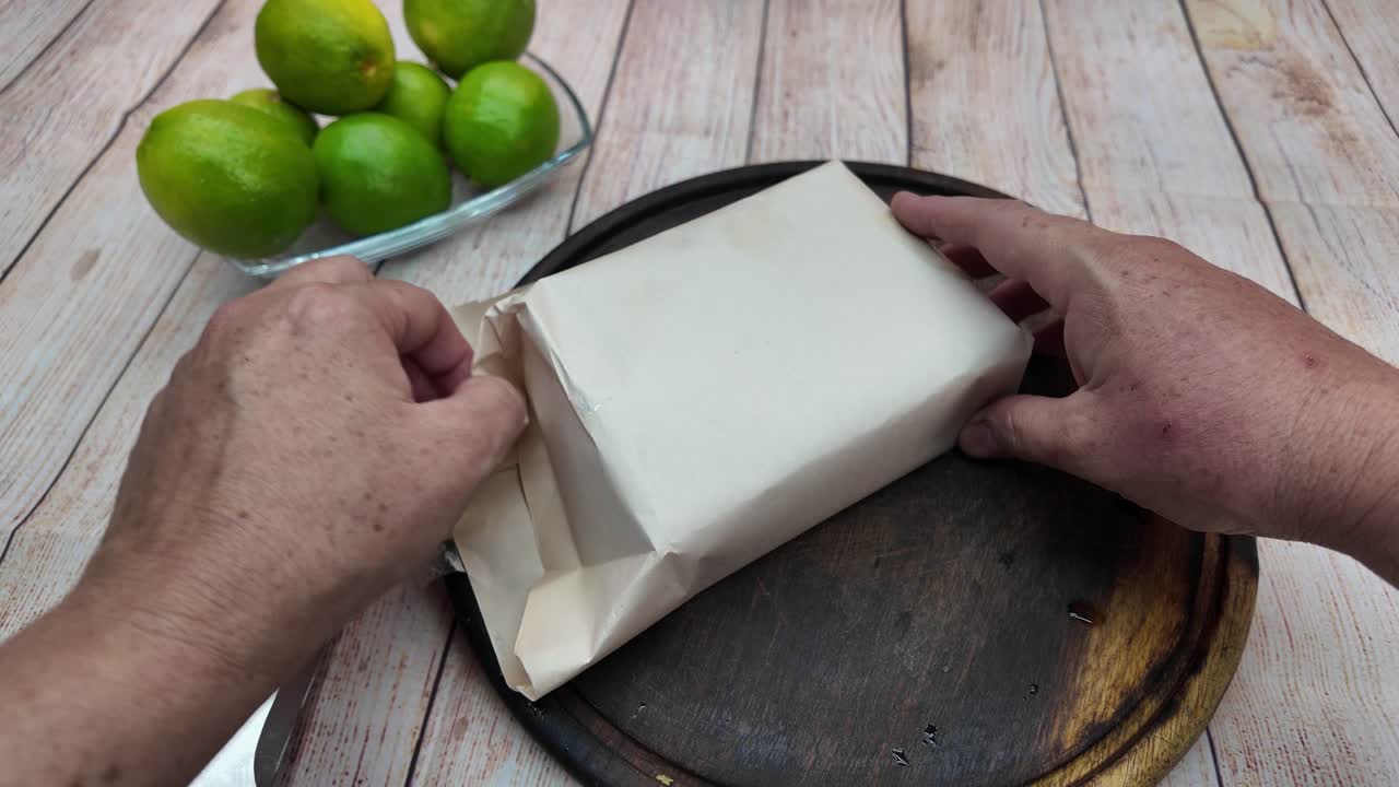 Hands carefully peel back the rustic paper from a dense block of panela, a traditional sweetener central to Latin American cuisine