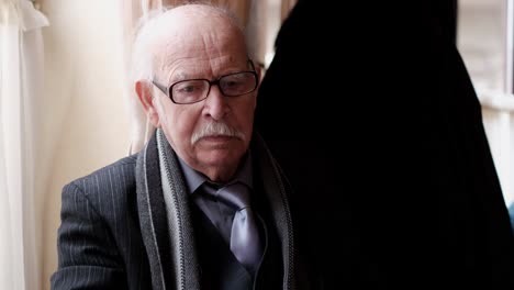 Portrait of an elderly man in a suit and glasses