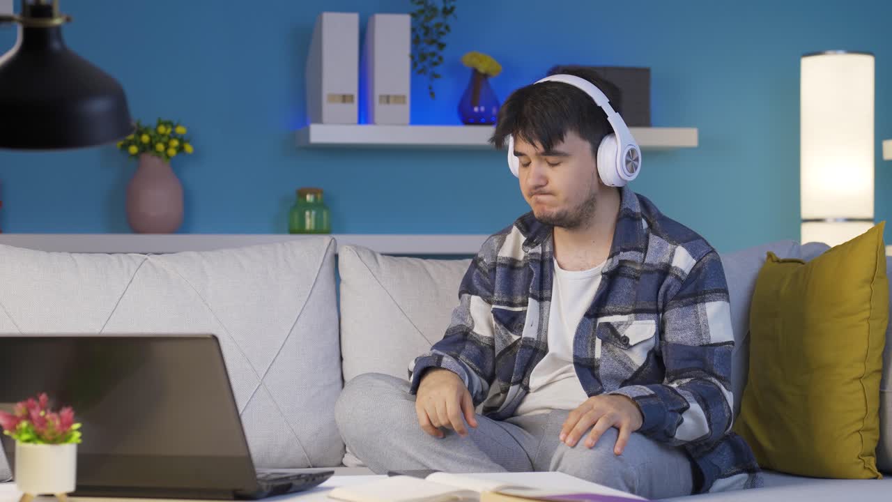 슬프고 불행한 남자가 밤에 집에서 음악을 듣고 있습니다.