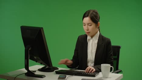 녹색 화면에 입력하는 책상에 앉아 사업가