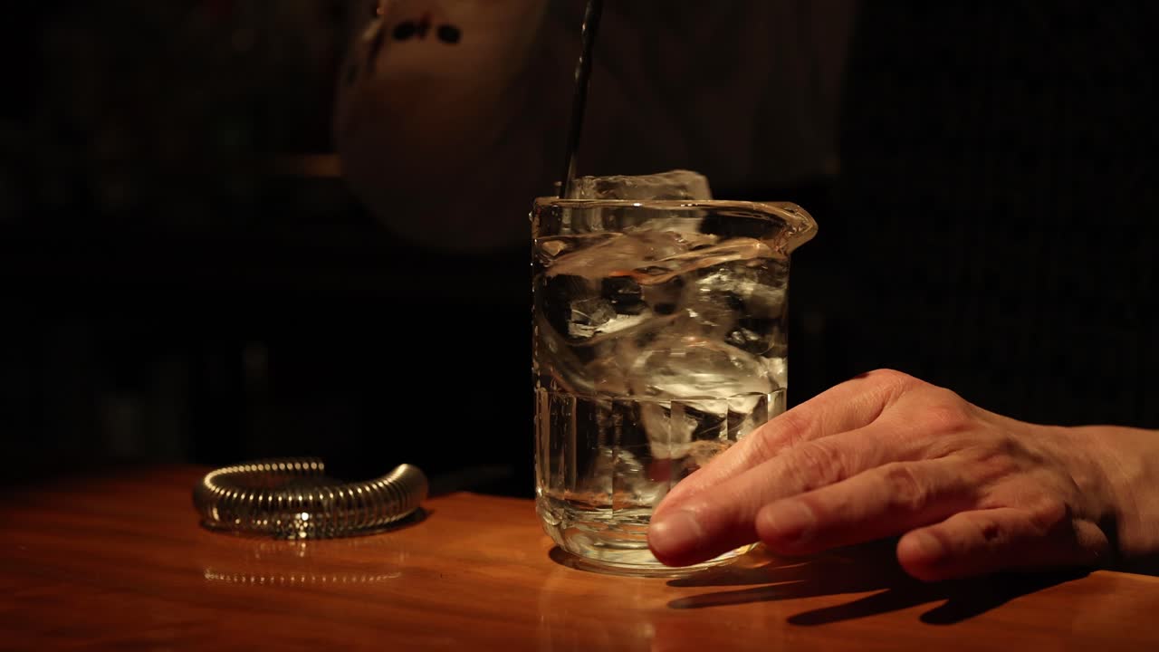 mezclando una bebida con hielo en un bar