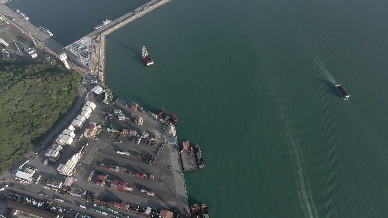 Tilt up to Hong Kong skyline from the city Container terminal and port with storage terminal and docked Ships, Aerial footage