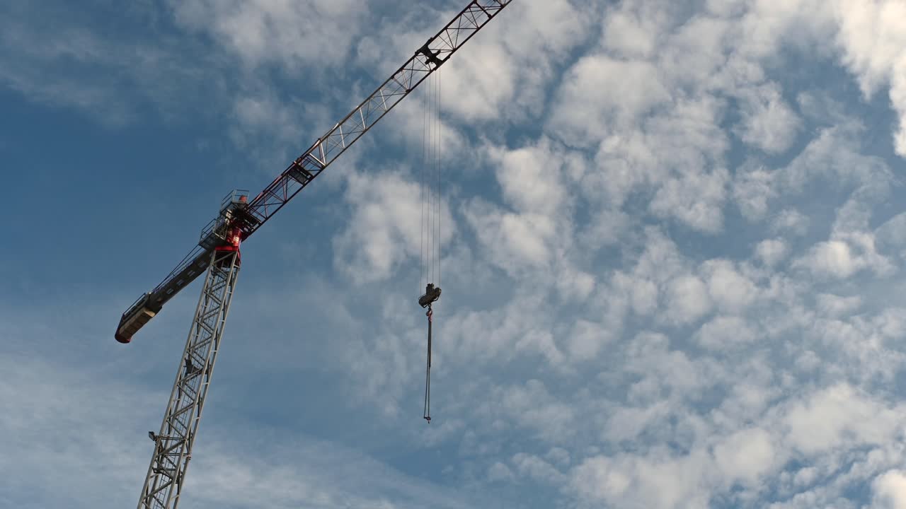 Bucharest, Romania - January 24, 2021: View of a crane machine moving with a blue, cloudy sky background