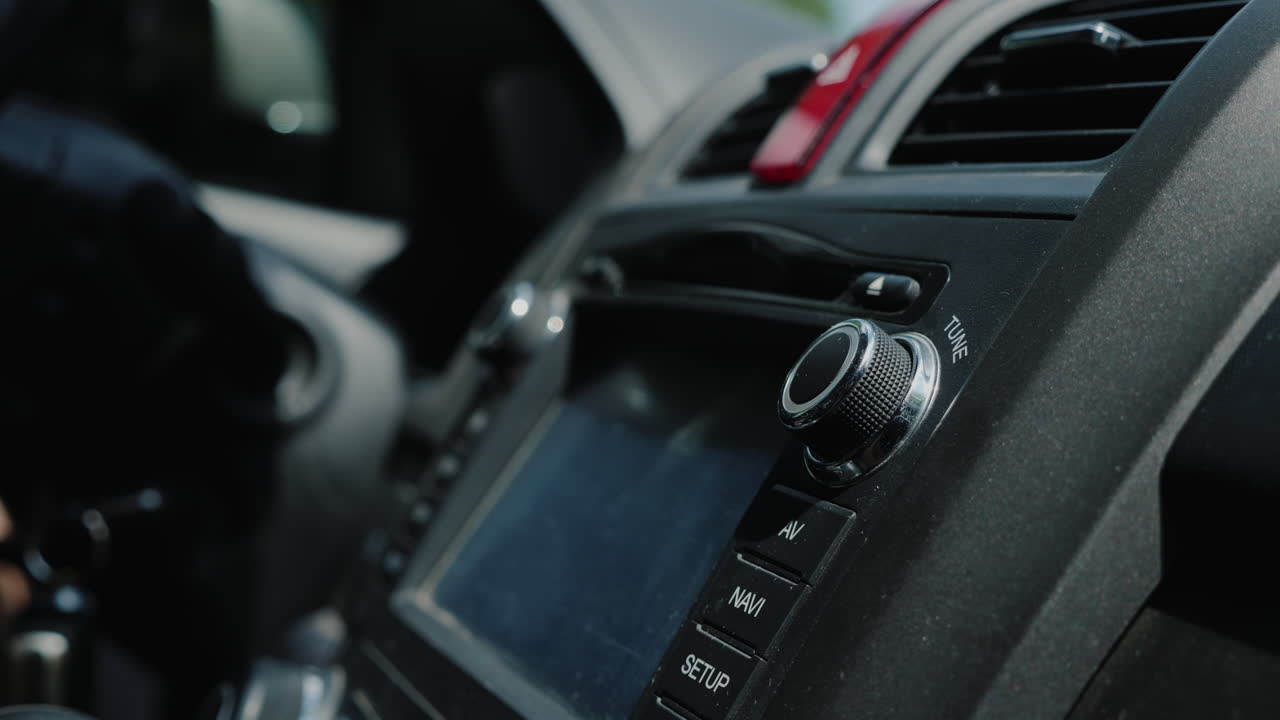 mano masculina ajusta la afinación de la toma de primer plano de la radio del coche