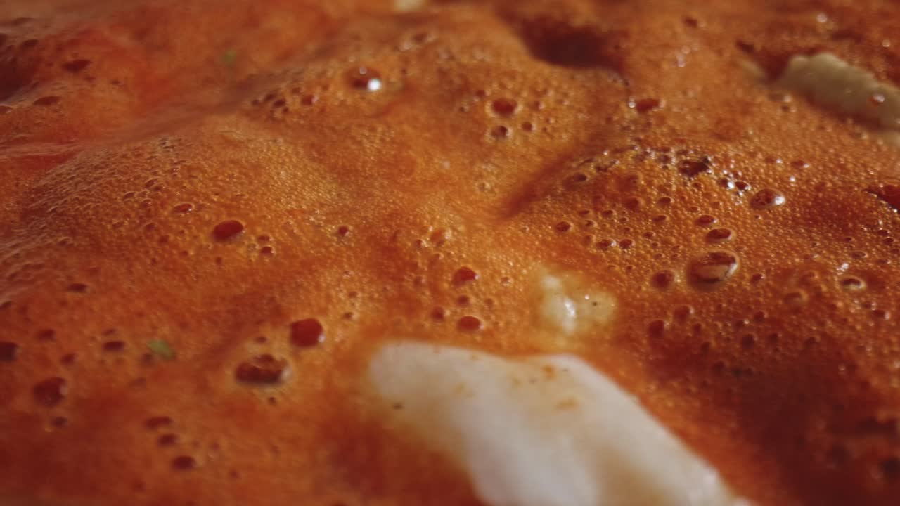 닭고기 조각을 곁들인 뜨거운 토마토 스튜 수프에 끓는 거품을 극단적으로 닫습니다.