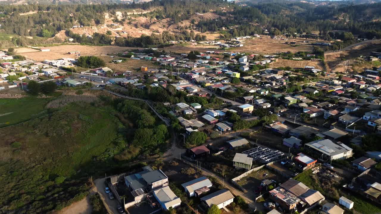 Vista orbital cinematográfica con dron de la arquitectura del pueblo costero y el barrio rural de La Vega de Pupuya cerca de la costa del Pacífico.