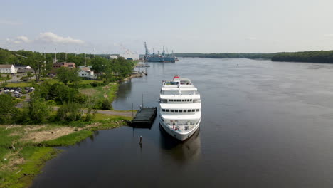 static drone footage of a cruise ship docking on the kennebec river, maine