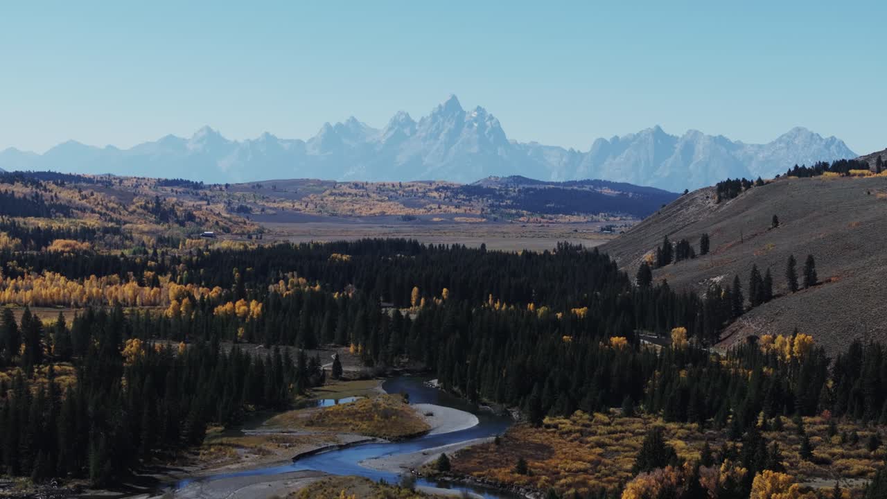 Filmato aereo di un fiume del Wyoming con la catena montuosa del Teton sullo sfondo durante l'autunno