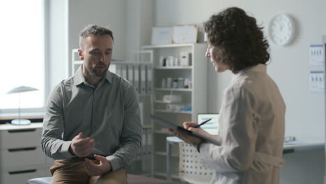 paciente discutiendo preocupaciones de salud con una doctora durante la consulta en la clínica