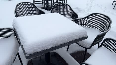 Schwenk-Auf-Tisch-Und-Stühle,-Die-Mit-Schnee-Bedeckt-Sind