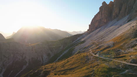 Amanecer-Sobre-Los-Picos-Del-Tirol-Del-Sur-Vista-Aérea-Siguiendo-Un-Camino-Sinuoso-En-La-Ladera-De-La-Montaña