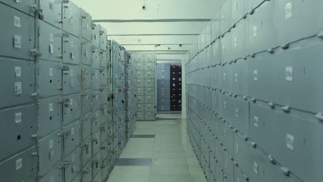 4k camera moves along safe deposit boxes in a bank vault room . security room with many locked cases and numbers  on it . safe metal cases with padlock for saving money , jewelry and documents