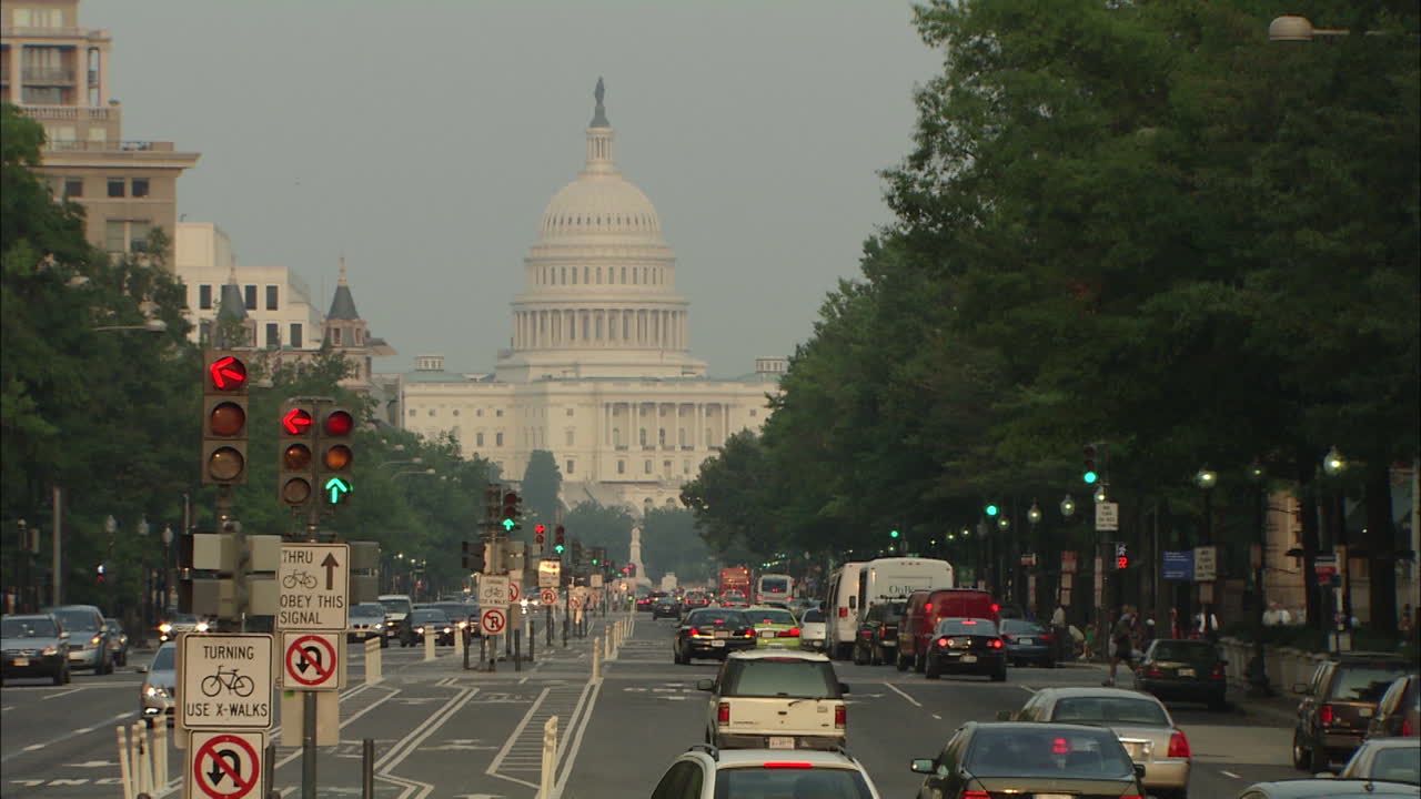 Cars Pass On Street With U.S. Capitol In Distance, Washington D.C.