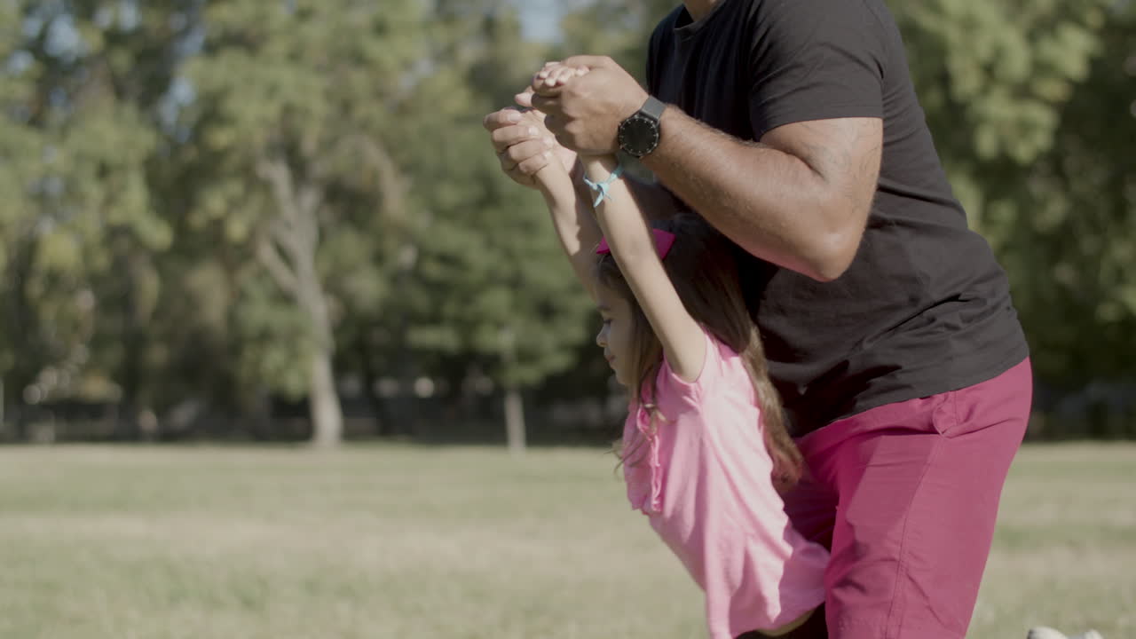 disparo medio del padre sosteniendo las manos de los niños y balanceándola