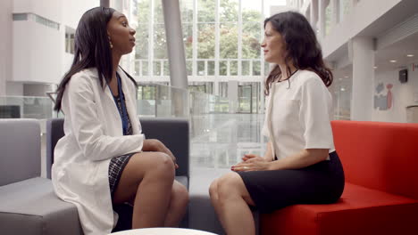 doctor and patient having meeting in hospital reception area