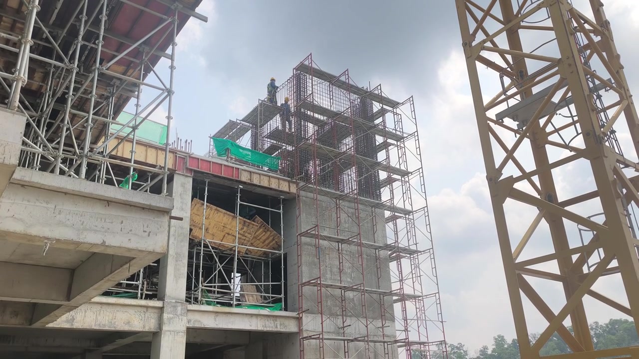 A large multi-storey high-rise building is under construction. The massive structure showcases active urban development and modern engineering.