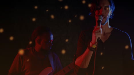 singer holding microphone and guitarist playing guitar on music stage with animated particles