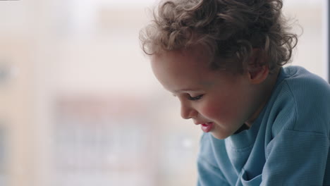 joyful-toddler-is-playing-against-window-in-snowy-day-in-winter-sitting-at-apartment-calm-and-peaceful-atmosphere