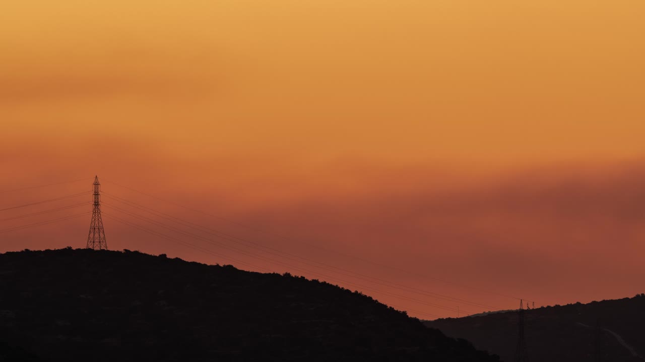 산과 전기 탑 위에 안개 낀 황금빛 새벽
