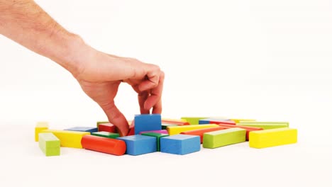 man hand playing building blocks