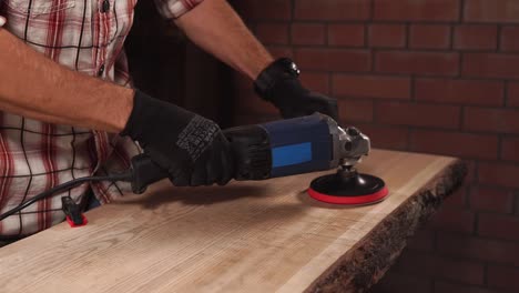 woodworker is using polishing machine for processing solid wood