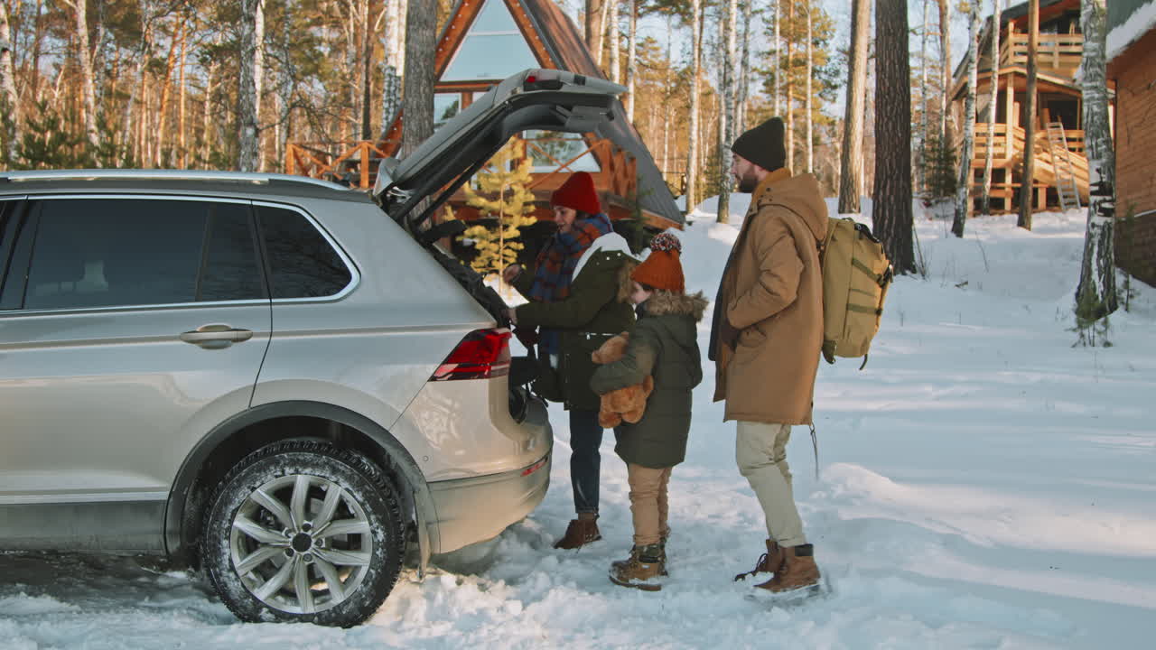 Family Arriving at Cozy Cabin in Forest in Winter