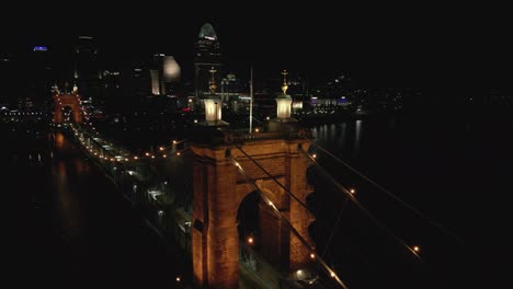 Panorámica-Nocturna-Aérea-Del-Puente-Colgante-Y-El-Centro-De-Cincinnati,-Ohio