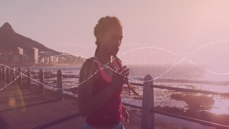 Animation-Eines-DNA-Strangs-über-Einer-Biracial-Frau,-Die-Auf-Der-Promenade-Läuft