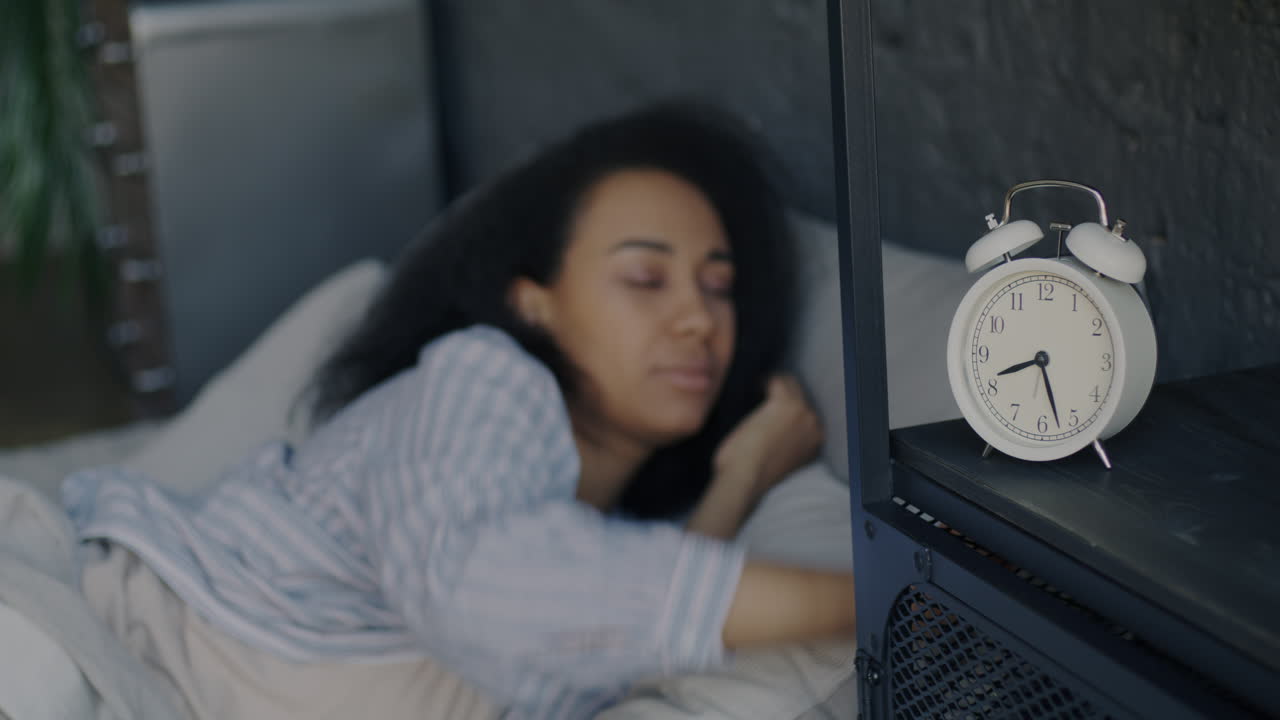 알람 시계와 함께 침대에서 잠자는 여자