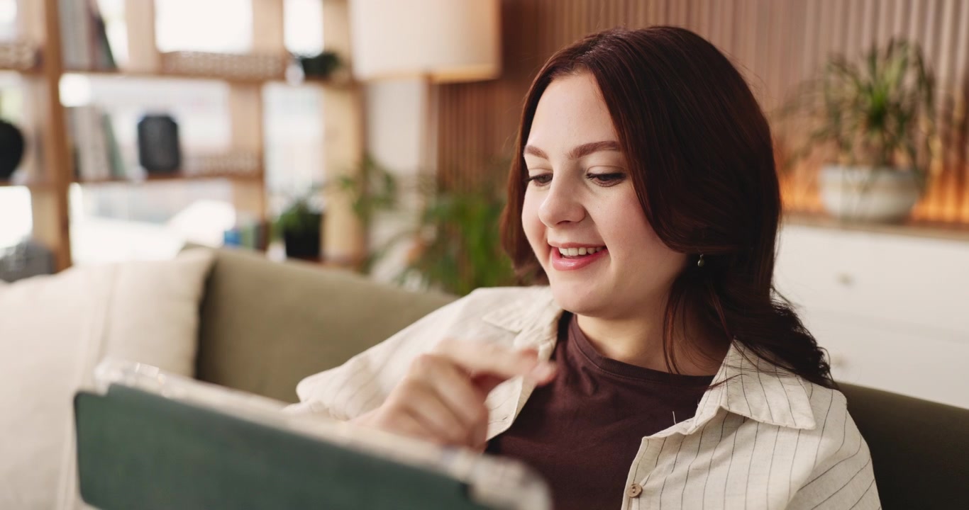 自宅でタブレットを使いながら考える若い女性