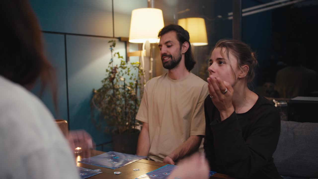 The guy the girl lost the board game and that's why they are sad. Their opponent is very happy and waving his arms
