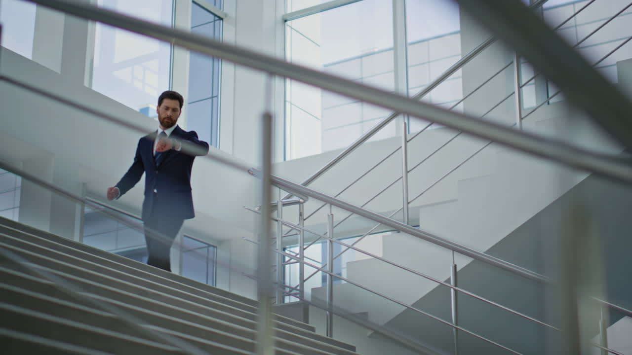 Successful ceo walking downstairs modern building. Confident businessman going